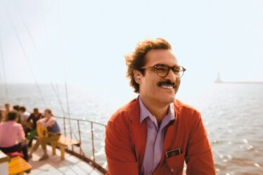 a man in glasses smiling on a boat