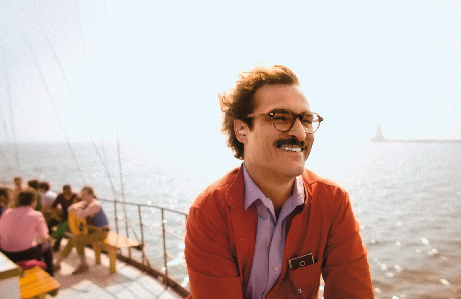 a man in glasses smiling on a boat